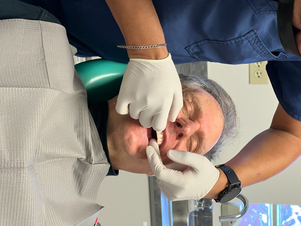 Clinic staff examining a patient during dental treatment