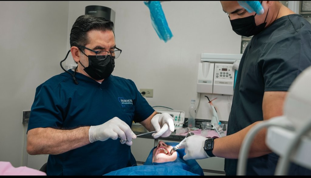Dr. Moguel and assistant performing dental implant procedure on patient
